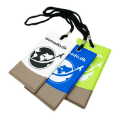 White, blue and green Nomado luggage tags against a black background